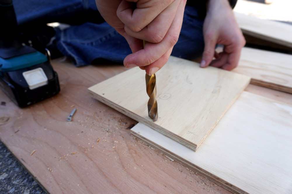 Manually cutting a countersink with a large drill bit.