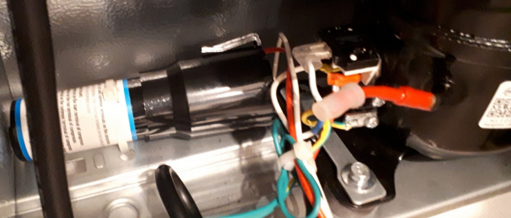 Capacitor is on the left, directly feeding into the compressor's start-windings.